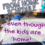 A person wearing a blue and white cap sits in front of a computer screen. Overlaid text reads: Steps to build a work from home schedule with kids... even though the kids are home! and scwbehindthescenes.com at the bottom.