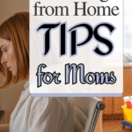 A woman with red hair sits at a desk working from home. Text overlay reads “Working from Home Tips for Moms.” In the background, children’s toys are visible in the kitchen area.