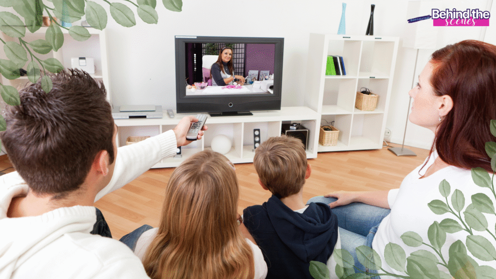 A family of four sits on a couch watching TV together in a bright living room. The father holds a remote, and leafy graphics frame the image. The screen shows a woman hosting a talk show. Behind the scenes text is in the top right. Creating a family media plan template