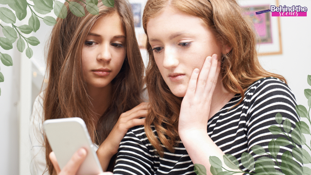 A couple of girls looking at a phone.