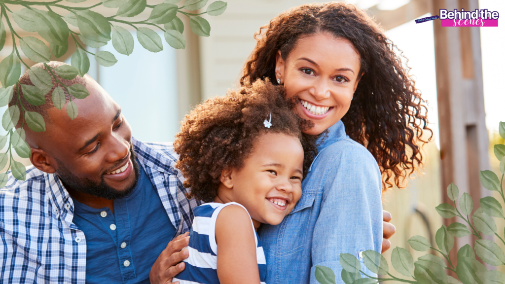 A smiling family of three, with a man, woman, and young girl, embrace outdoors. Leafy borders frame the image, and “Behind the scenes” text appears in the top right corner. The atmosphere is warm and cheerful.