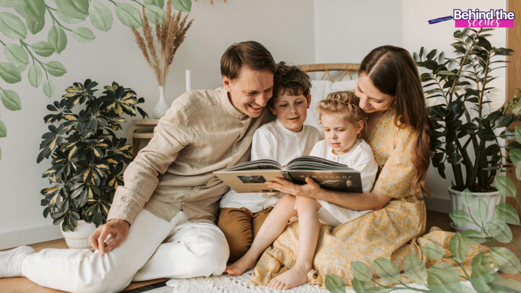 A smiling family of four sits on the floor in a cozy, plant-filled room, reading a book together. The parents and two children are close, sharing the book and enjoying quality time. Behind the scenes text appears in the corner.