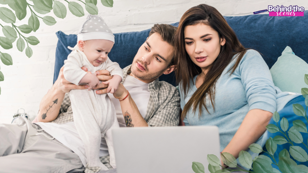 A young couple sits on a bed with a laptop, the man holding a baby in front of him. The mother and father, exploring career burnout recovery tips, look at the screen together. Decorative green leaves frame the image; "Behind the scenes" appears top right.